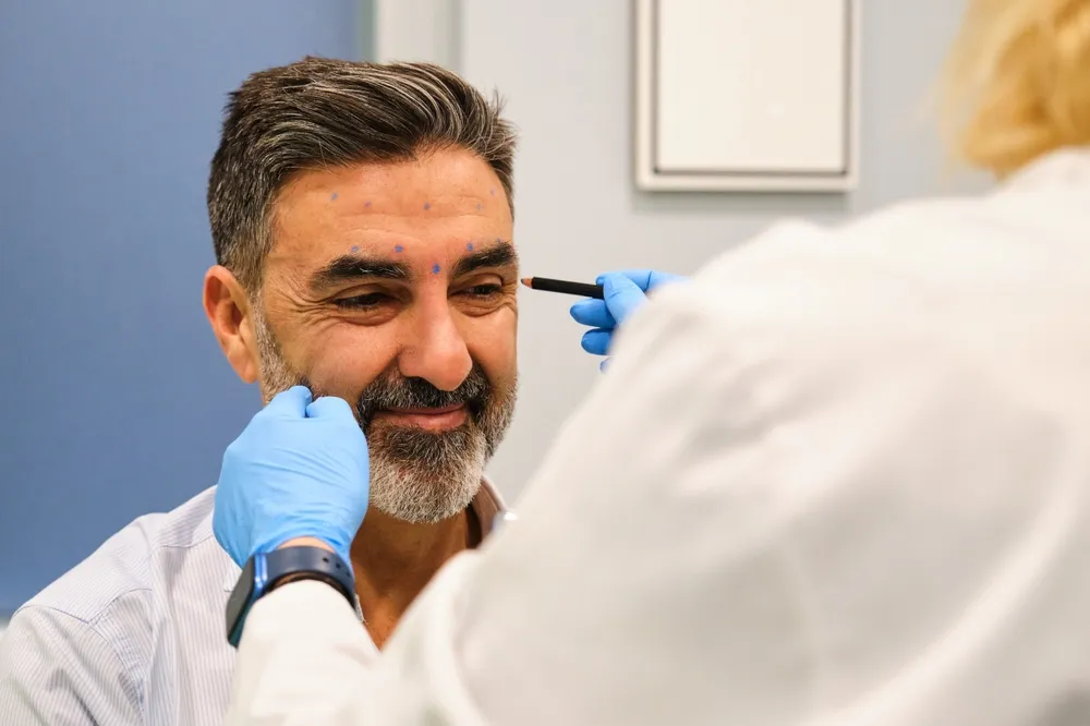 Préparation du visage d’un homme pour injection de Botox