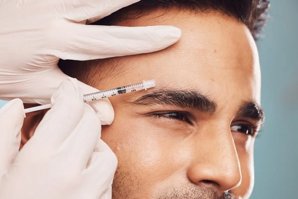 Un homme se fait injecter du Botox en haut des sourcils pour rajeunir son front